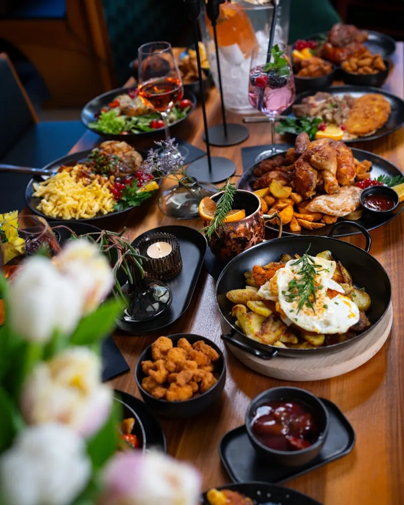 Gedeckter Restauranttisch mit Tulpen und Gerichten